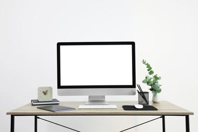 Photo of Modern computer with blank screen on desk, space for design. Comfortable workplace