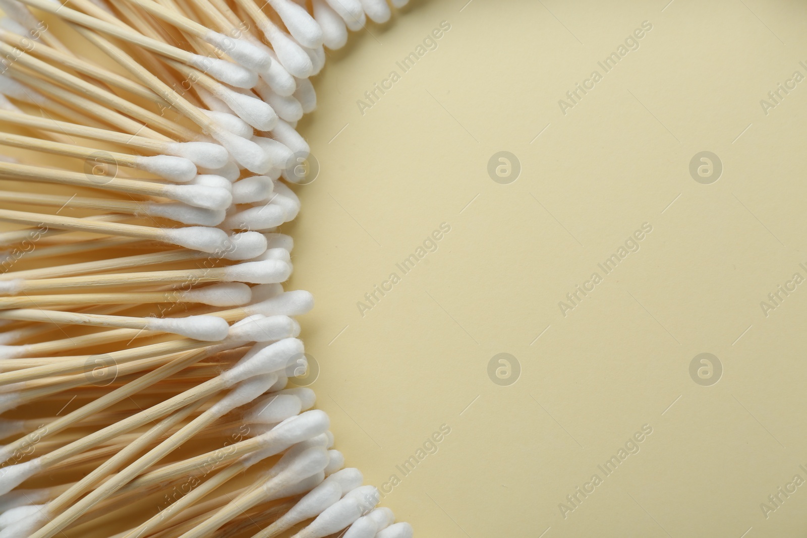 Photo of Many wooden cotton buds on beige background, flat lay. Space for text