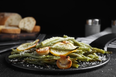 Photo of Delicious baked green beans served on black table, closeup