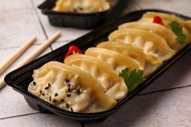Photo of Delicious gyoza (asian dumplings) with sesame seeds on table, closeup