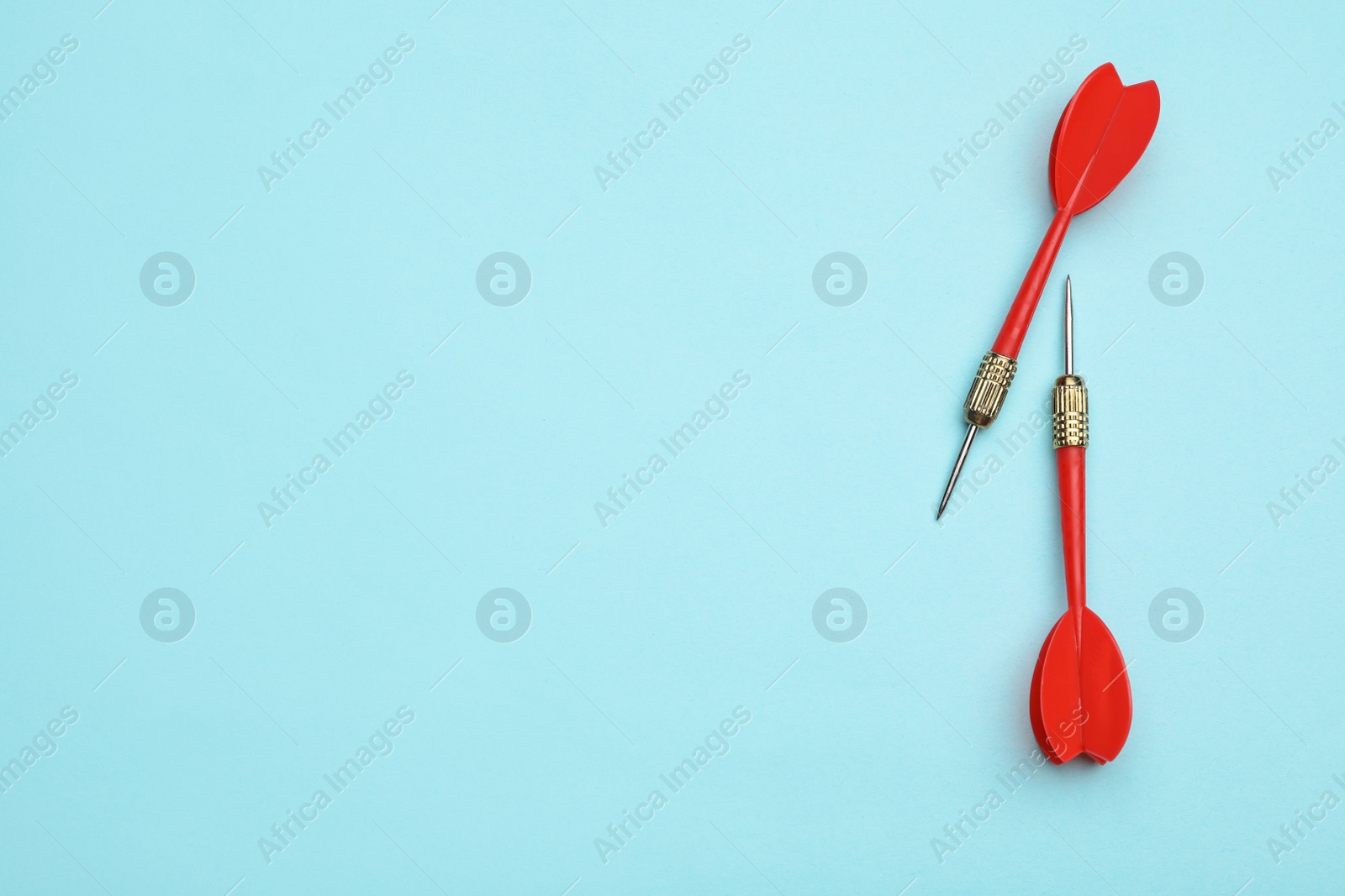 Photo of Red dart arrows on blue background, flat lay with space for text