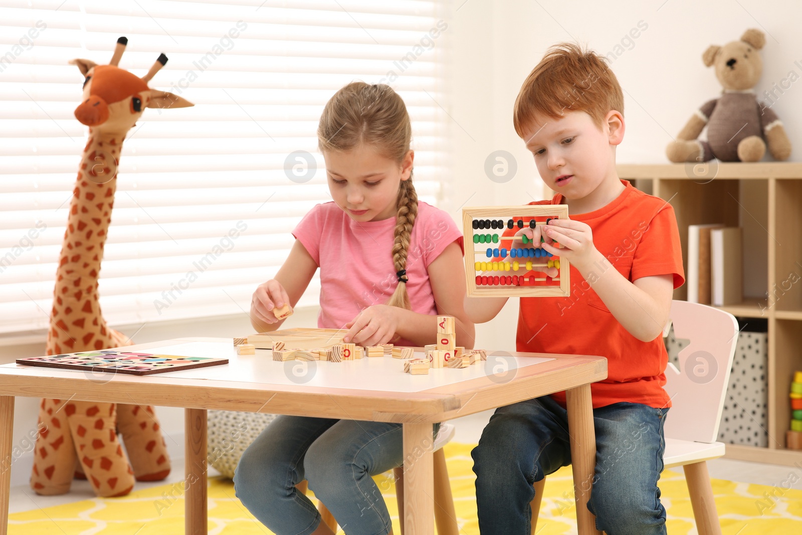 Photo of Children playing with different math game kits at desk in room. Study mathematics with pleasure