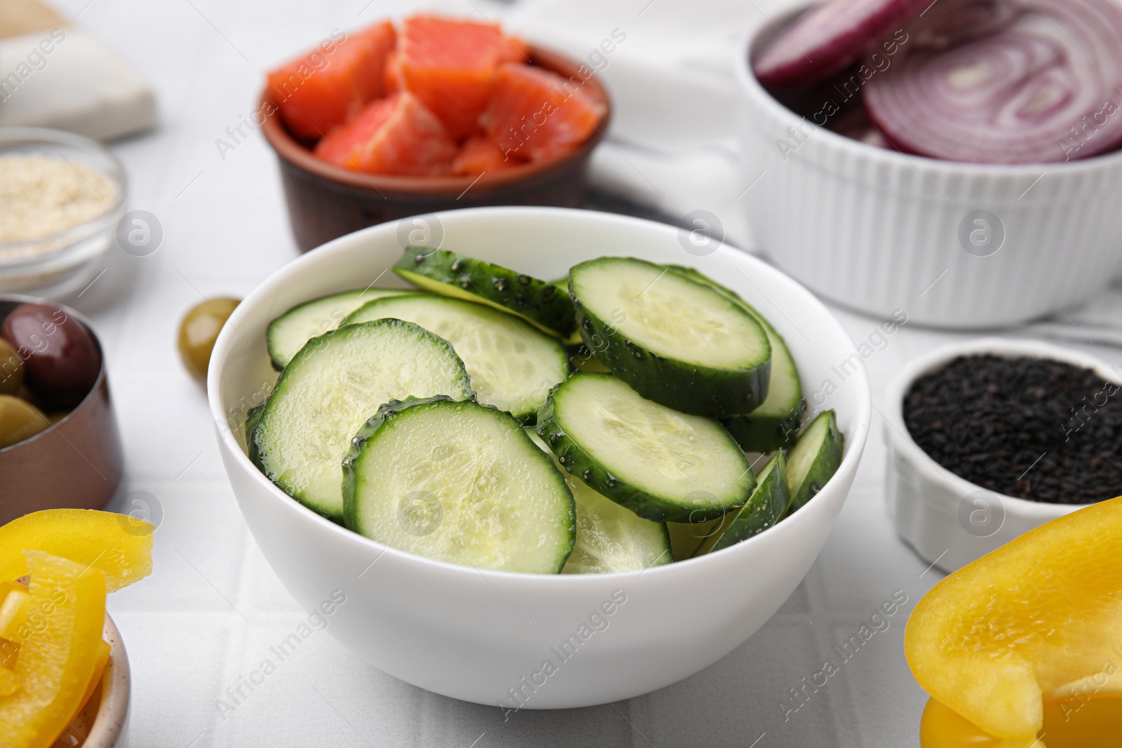 Photo of Ingredients for poke bowl on white checkered table, closeup