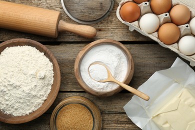 Photo of Ingredients for making dough, rolling pin and sieve on wooden table, flat lay