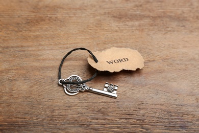 Vintage key with tag on wooden table. Keyword concept