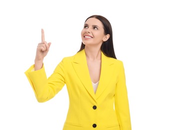 Beautiful happy businesswoman in yellow suit pointing at something on white background