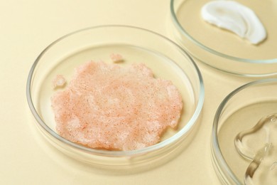 Many Petri dishes and cosmetic products on beige background, closeup