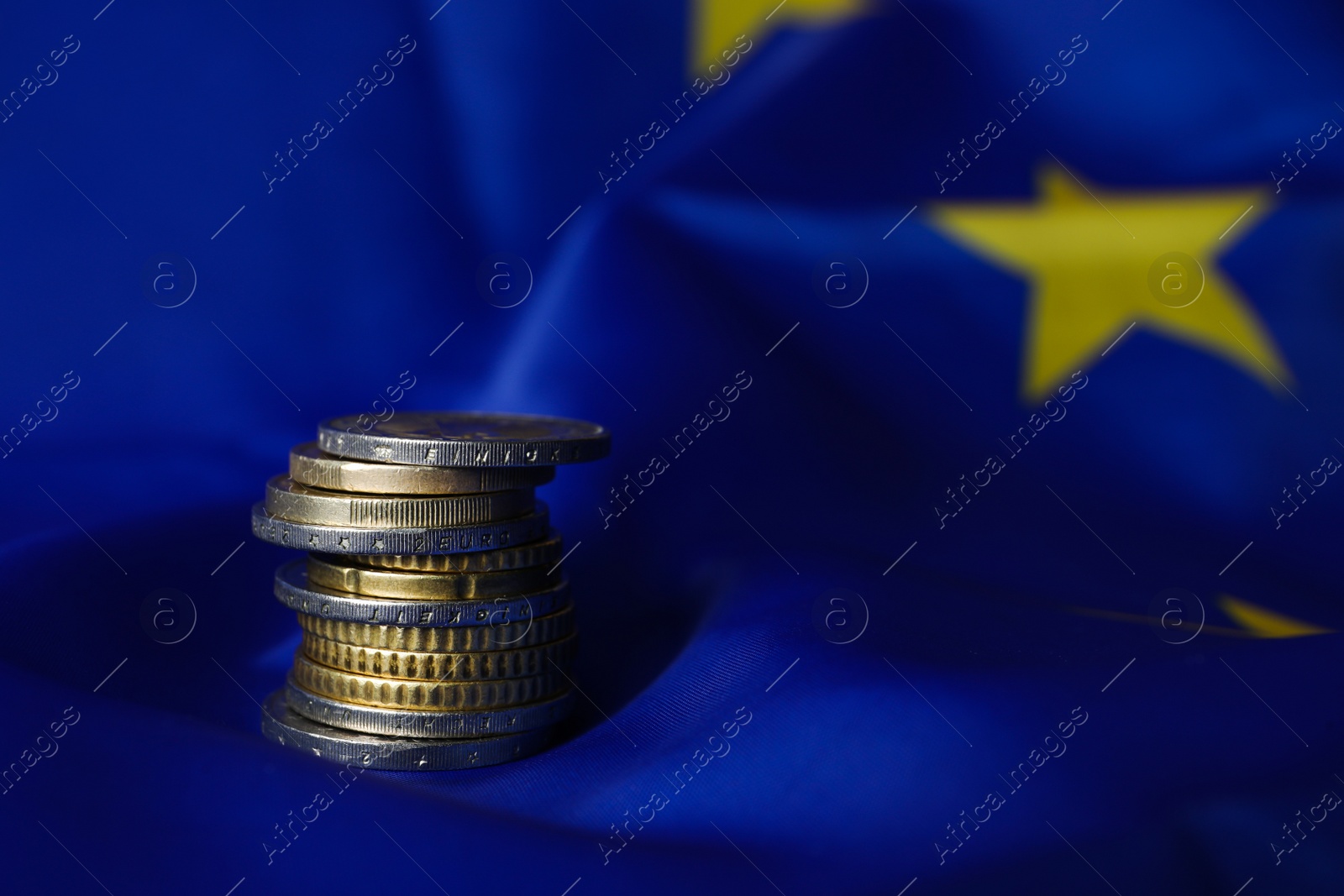 Photo of Stack of coins on European Union flag, space for text