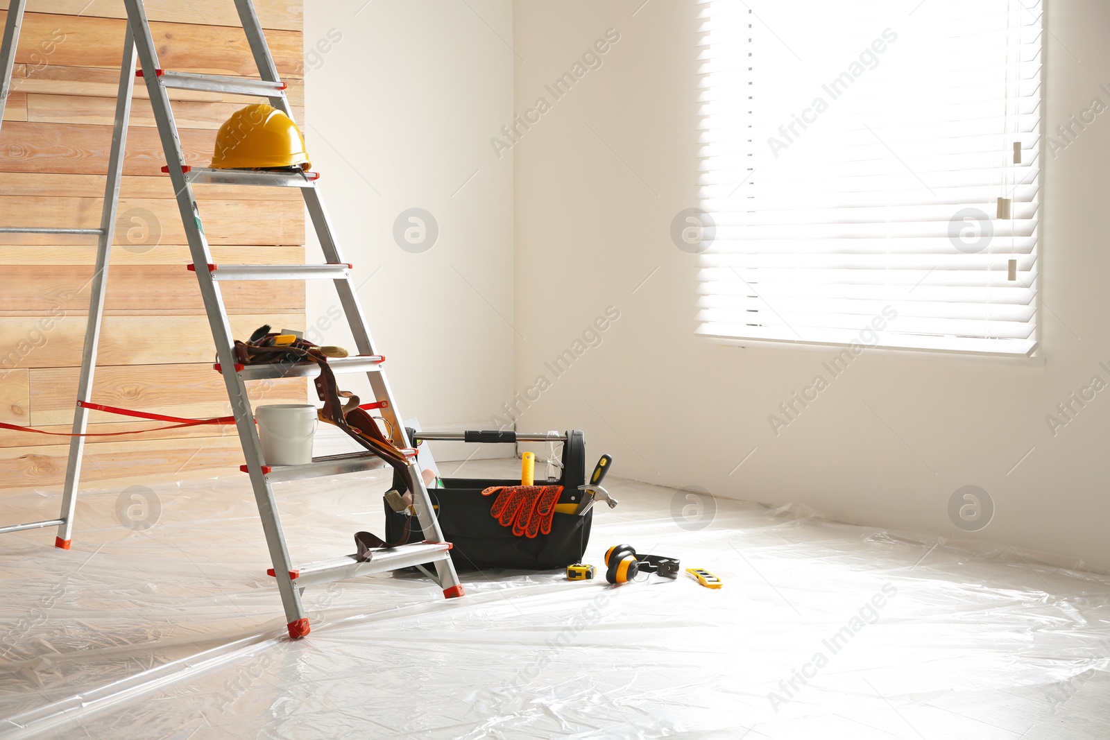 Photo of Stepladder and different tools in room. Interior renovation