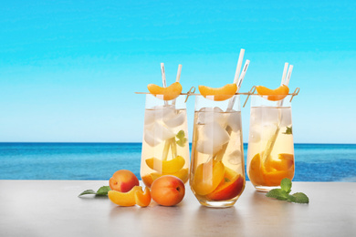 Image of Tasty refreshing drink on table against sea