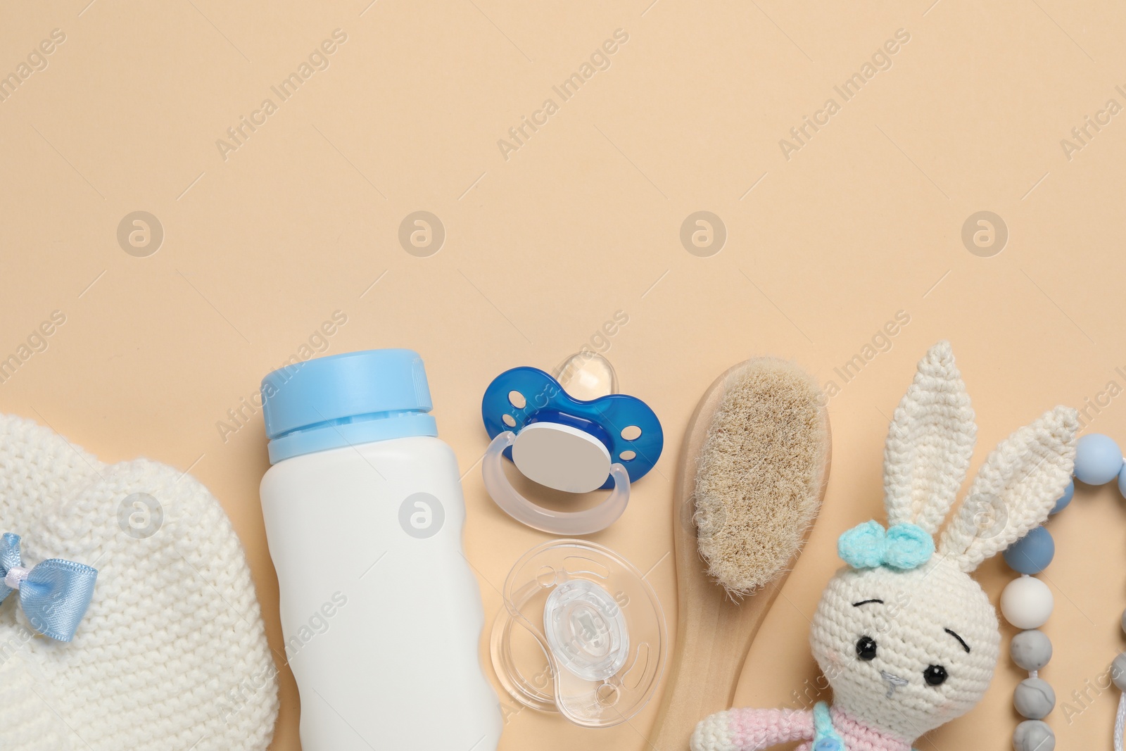 Photo of Flat lay composition with pacifiers and other baby stuff on beige background. Space for text