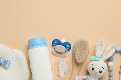 Photo of Flat lay composition with pacifiers and other baby stuff on beige background. Space for text