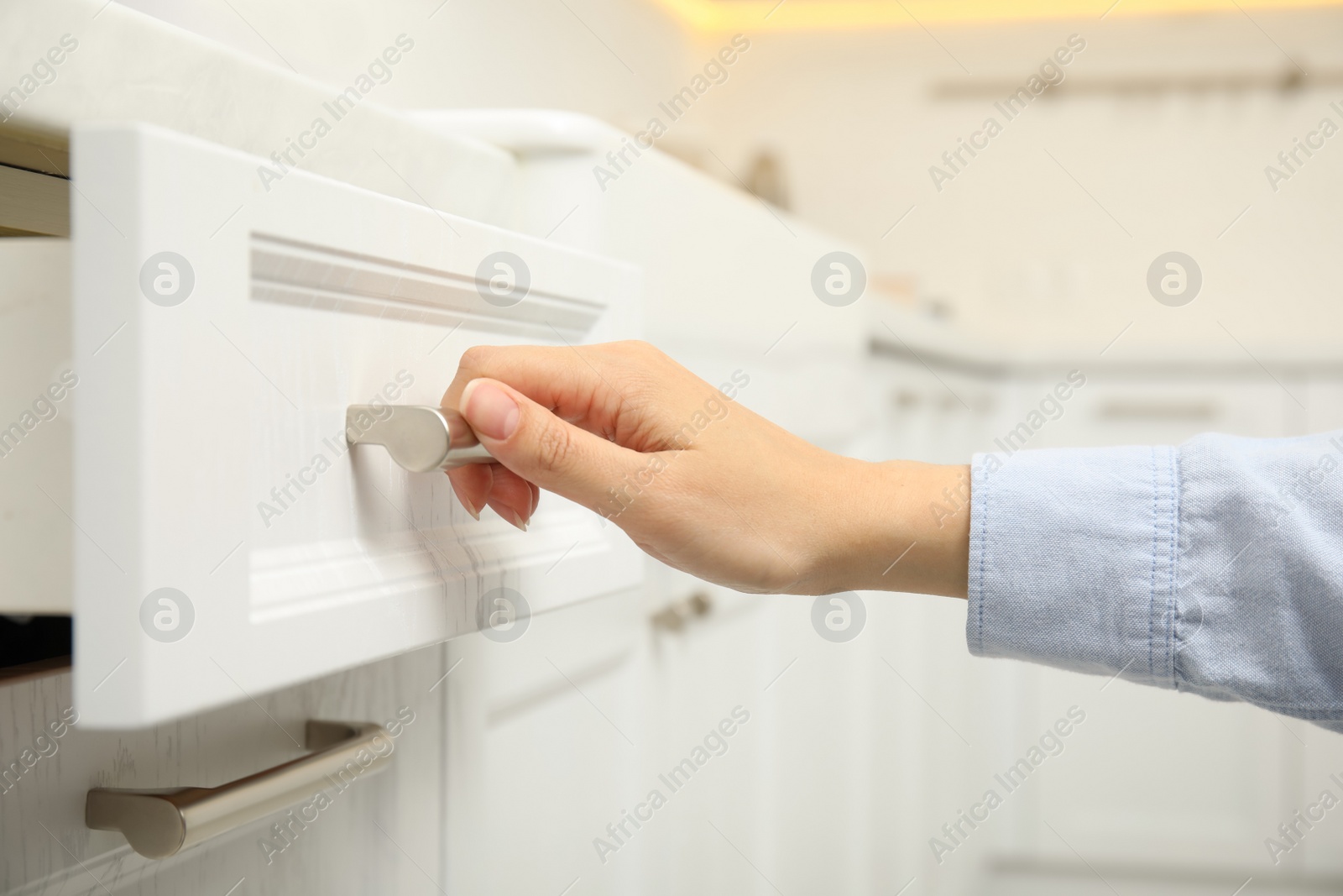 Photo of Woman opening drawer in kitchen, closeup view