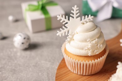 Photo of Tasty Christmas cupcake with snowflakes on grey table. Space for text