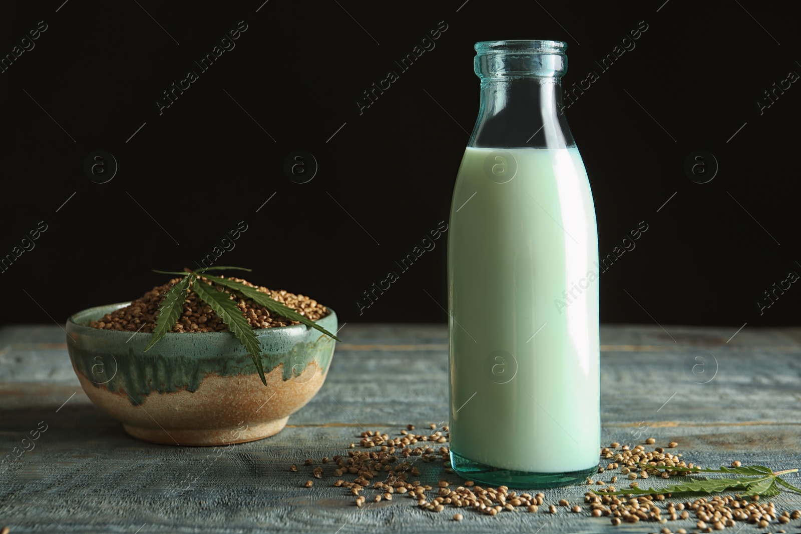 Photo of Bottle of hemp milk on wooden table