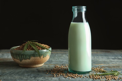 Photo of Bottle of hemp milk on wooden table