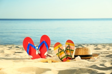 Composition with stylish beach accessories on sand near sea