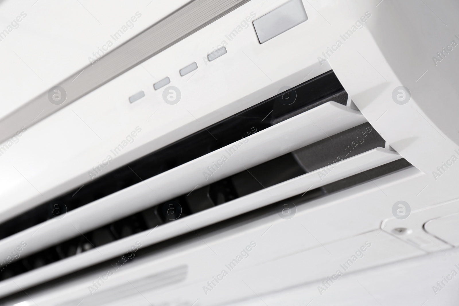 Photo of Modern air conditioner on white wall indoors, closeup view