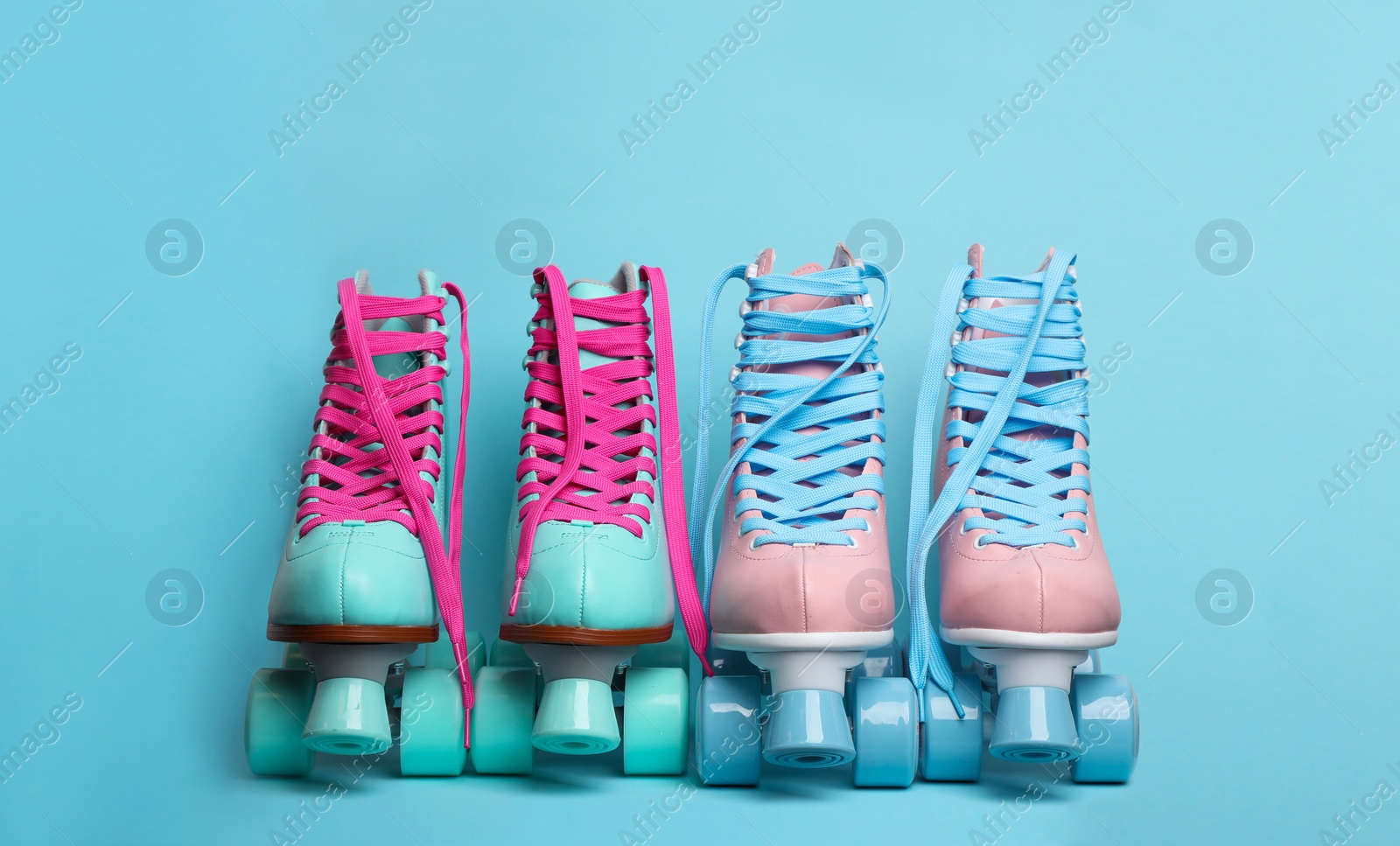 Photo of Pairs of stylish quad roller skates on color background