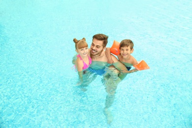 Photo of Happy father with children in swimming pool