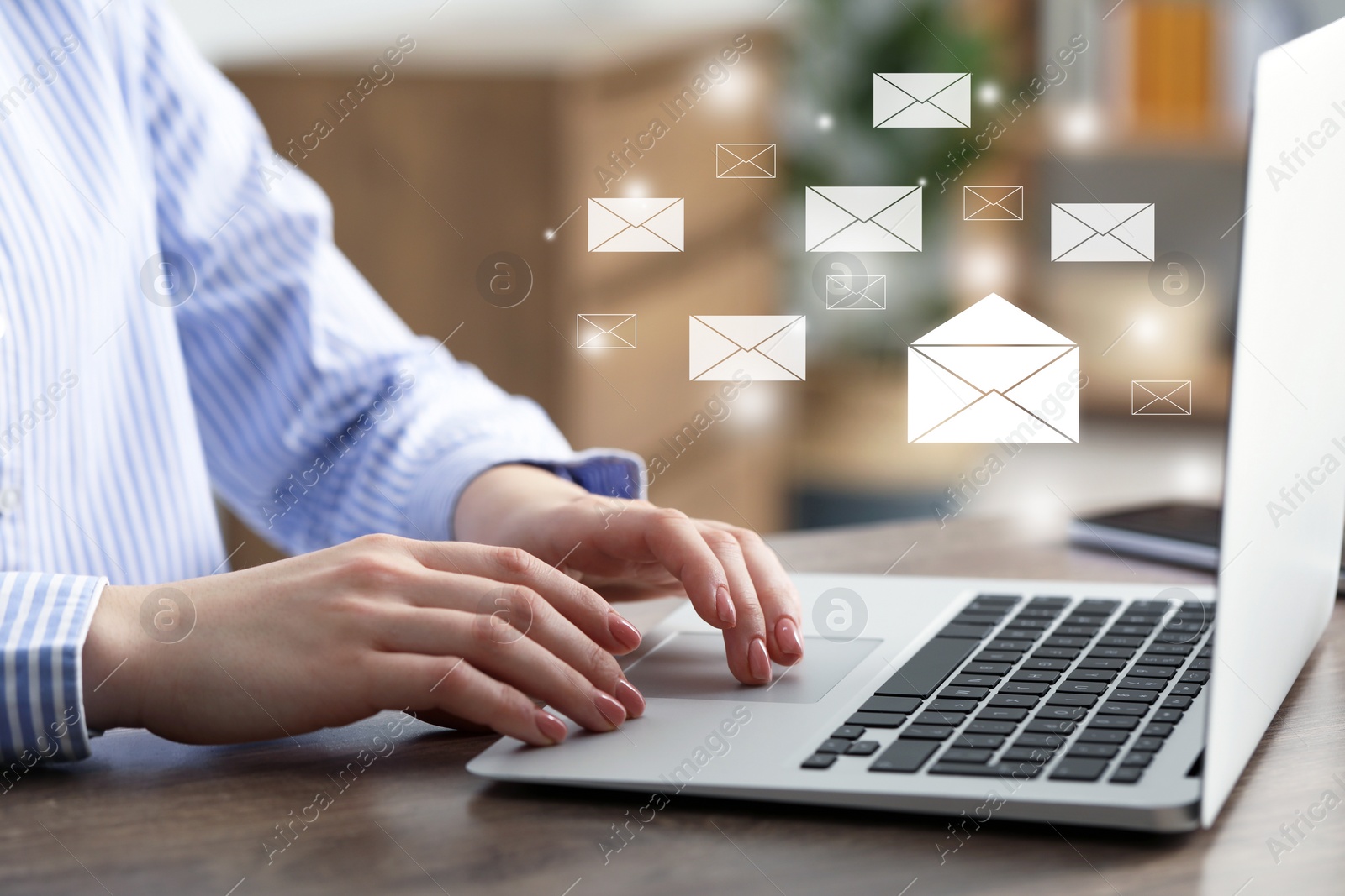 Image of Email. Woman using laptop at table, closeup. Letter illustrations over device