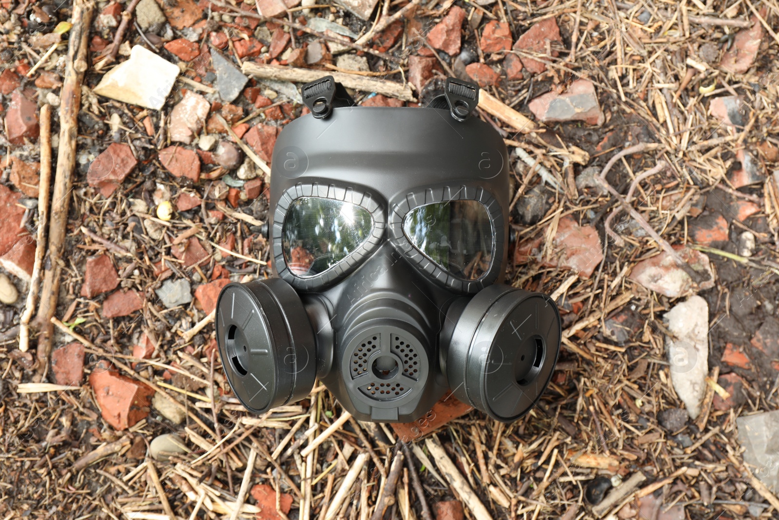 Photo of One gas mask on ground, top view