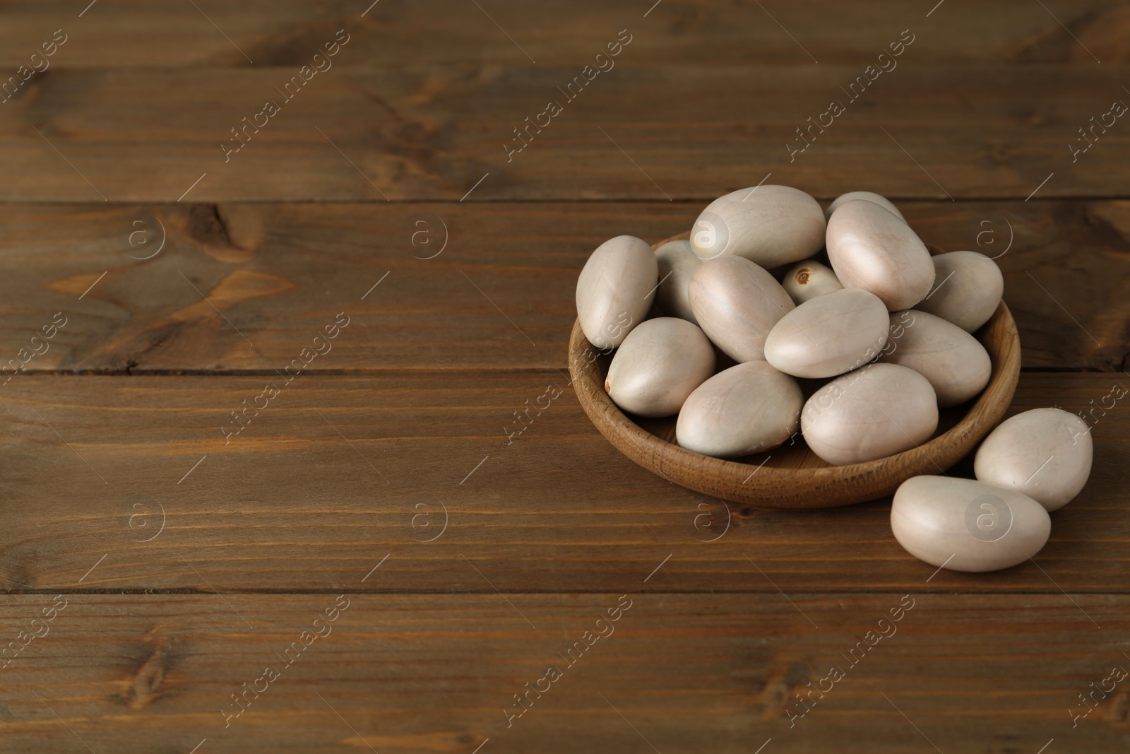 Photo of Raw jackfruit seeds on wooden table. Space for text