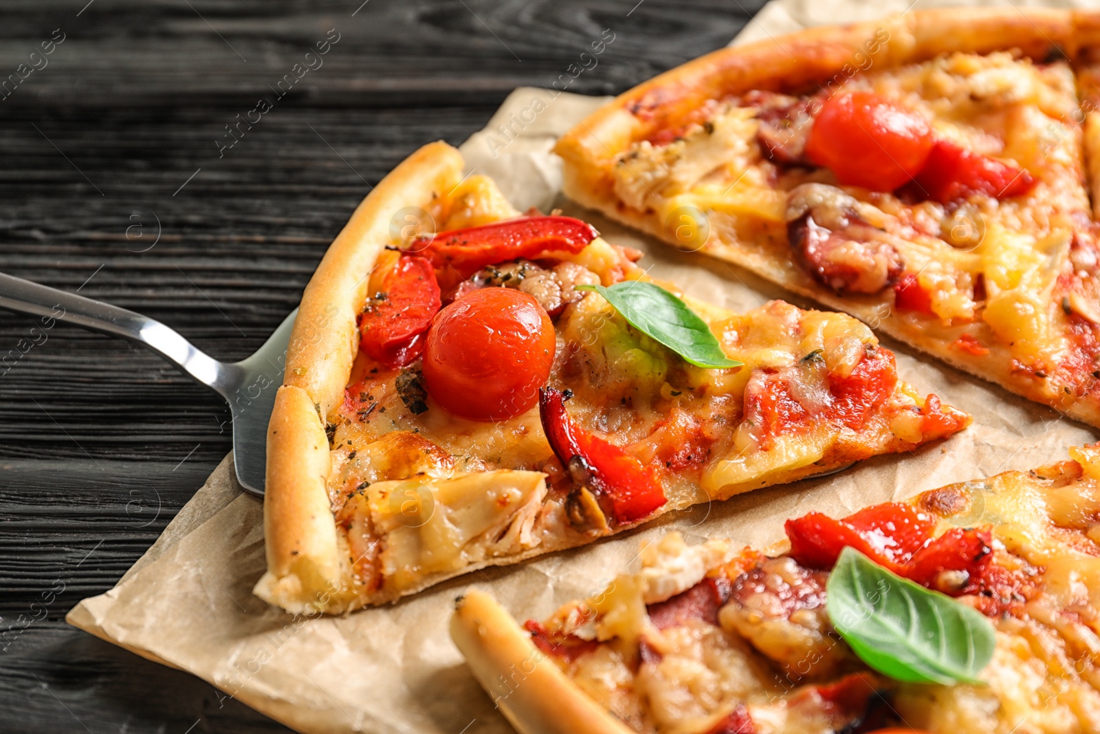 Photo of Delicious pizza with tomatoes and sausages on table