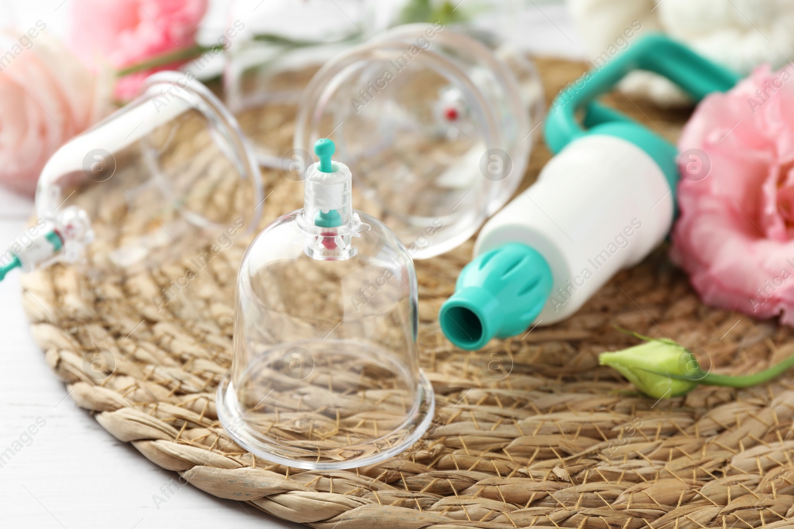 Photo of Cupping therapy. Plastic cups and hand pump on white table, closeup. Space for text