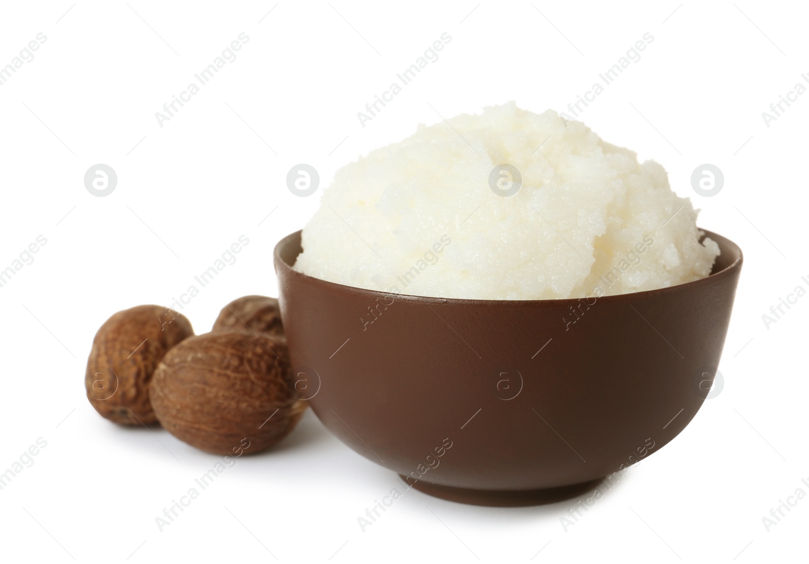 Photo of Shea butter in bowl and nuts isolated on white