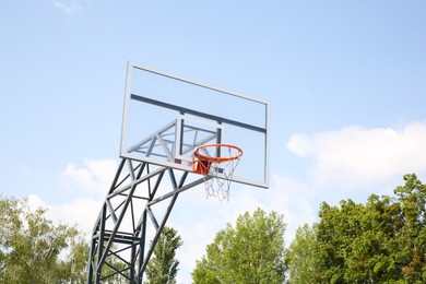 Photo of Basketball backboard with hoop outdoors on sunny day
