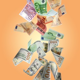 Image of Money exchange. Many dollars and euro banknotes falling on pale orange background