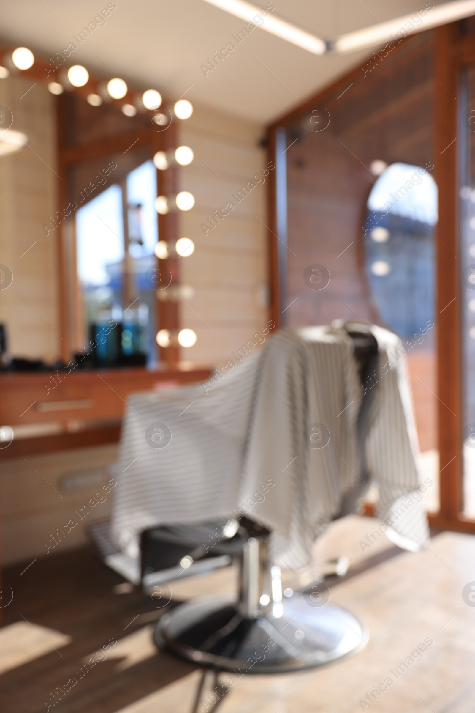 Photo of Blurred view of stylish barbershop interior with hairdresser workplace