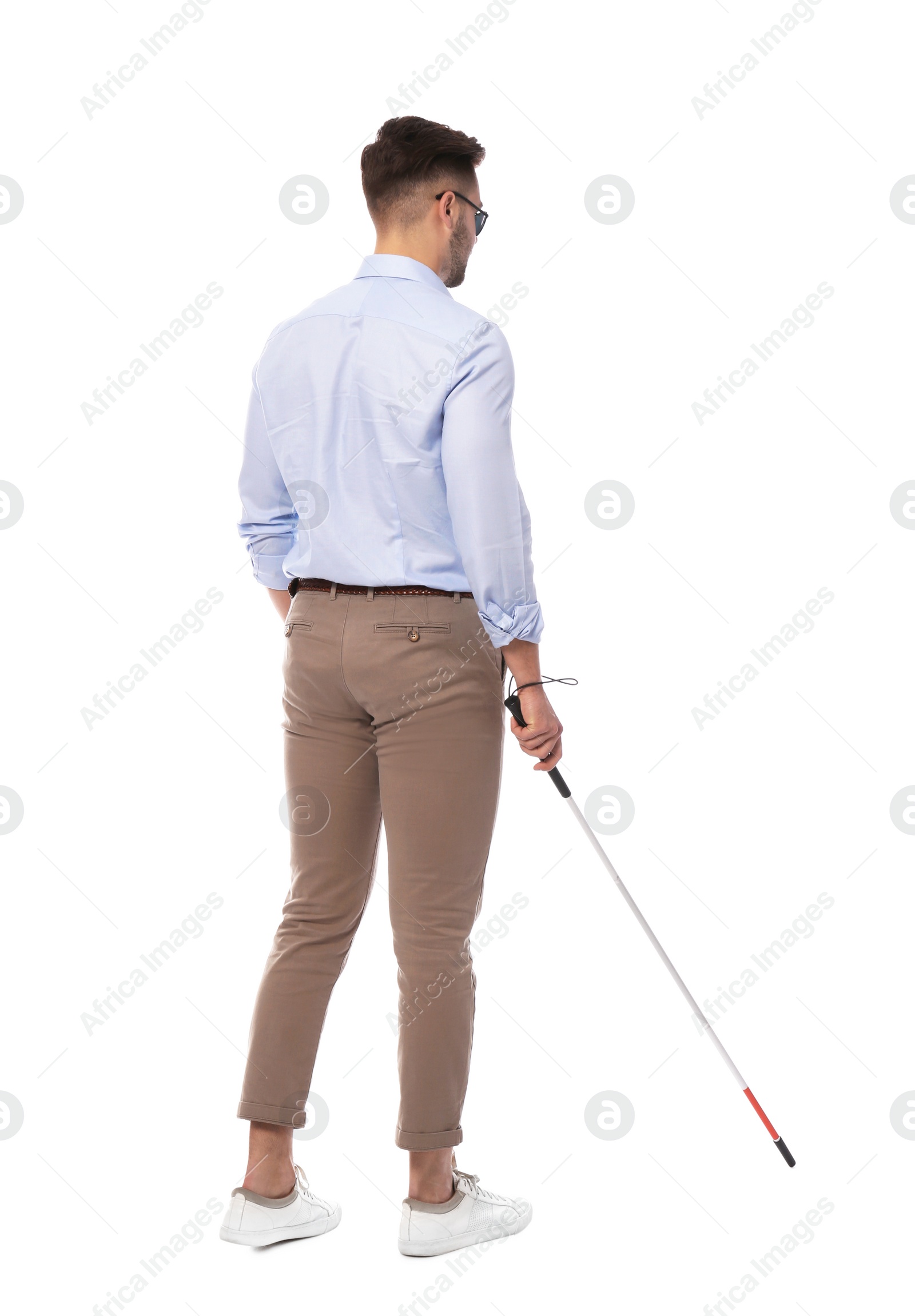 Photo of Young blind person with long cane walking on white background