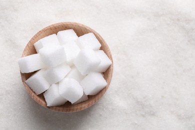 Photo of Different types of white sugar and bowl as background, top view. Space for text