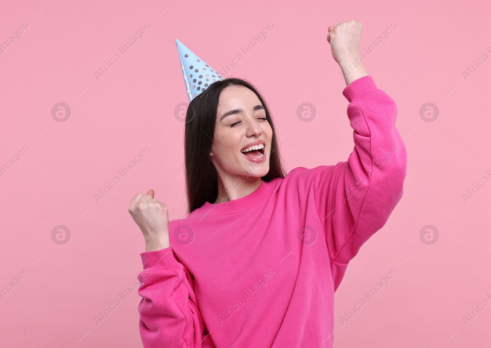 Photo of Happy woman in party hat on pink background