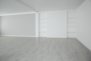 Empty room with modern ceiling fan and laminated floor