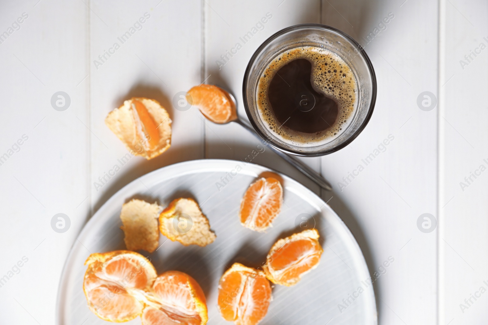 Photo of Fresh ripe tangerines and cup of coffee on white wooden table, flat lay