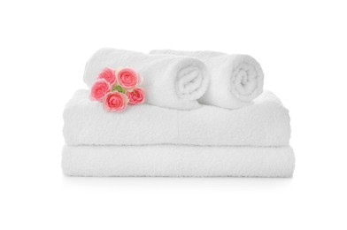 Fresh clean towels with roses on white background
