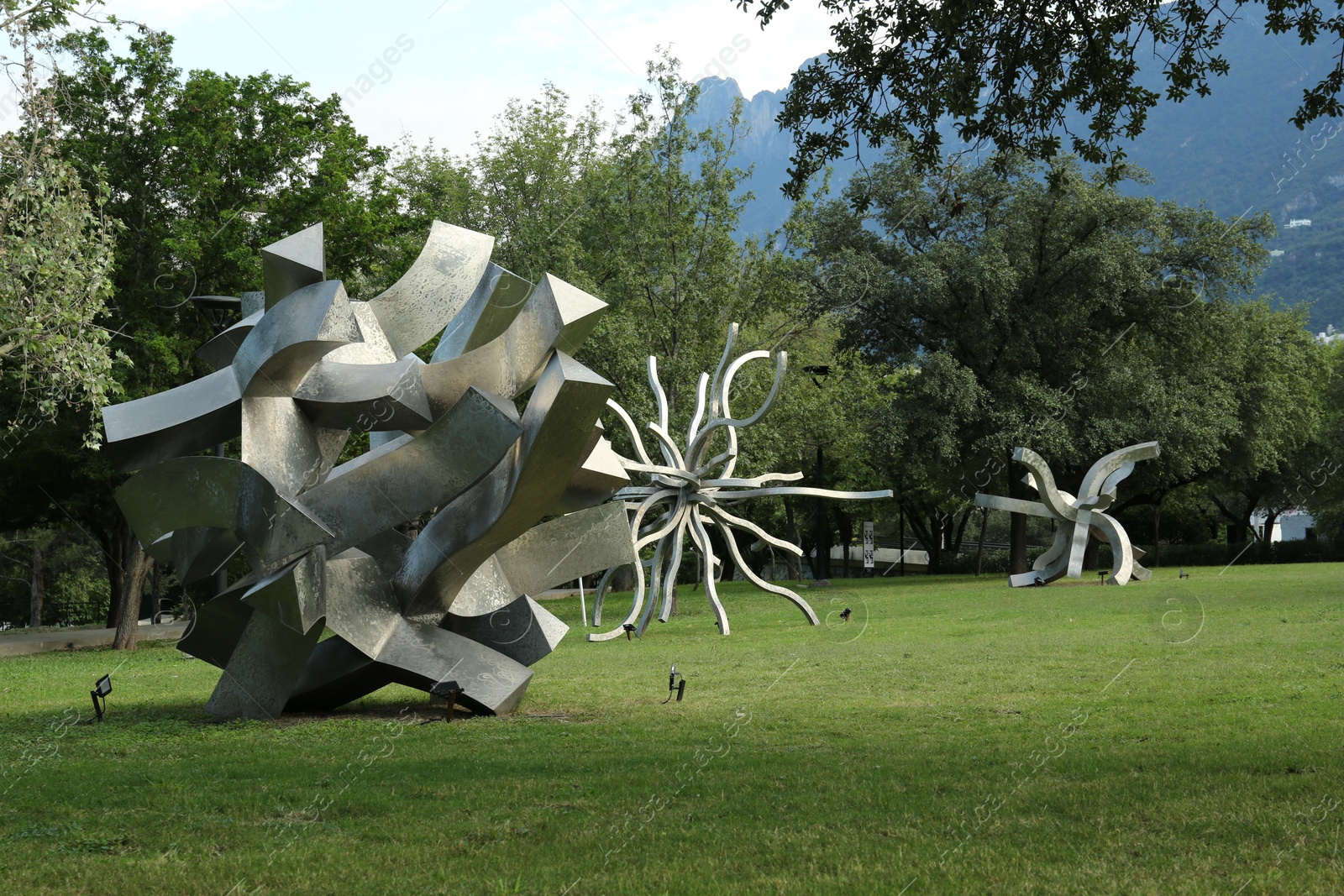 Photo of Picturesque view of beautiful park with metal figures on green grass