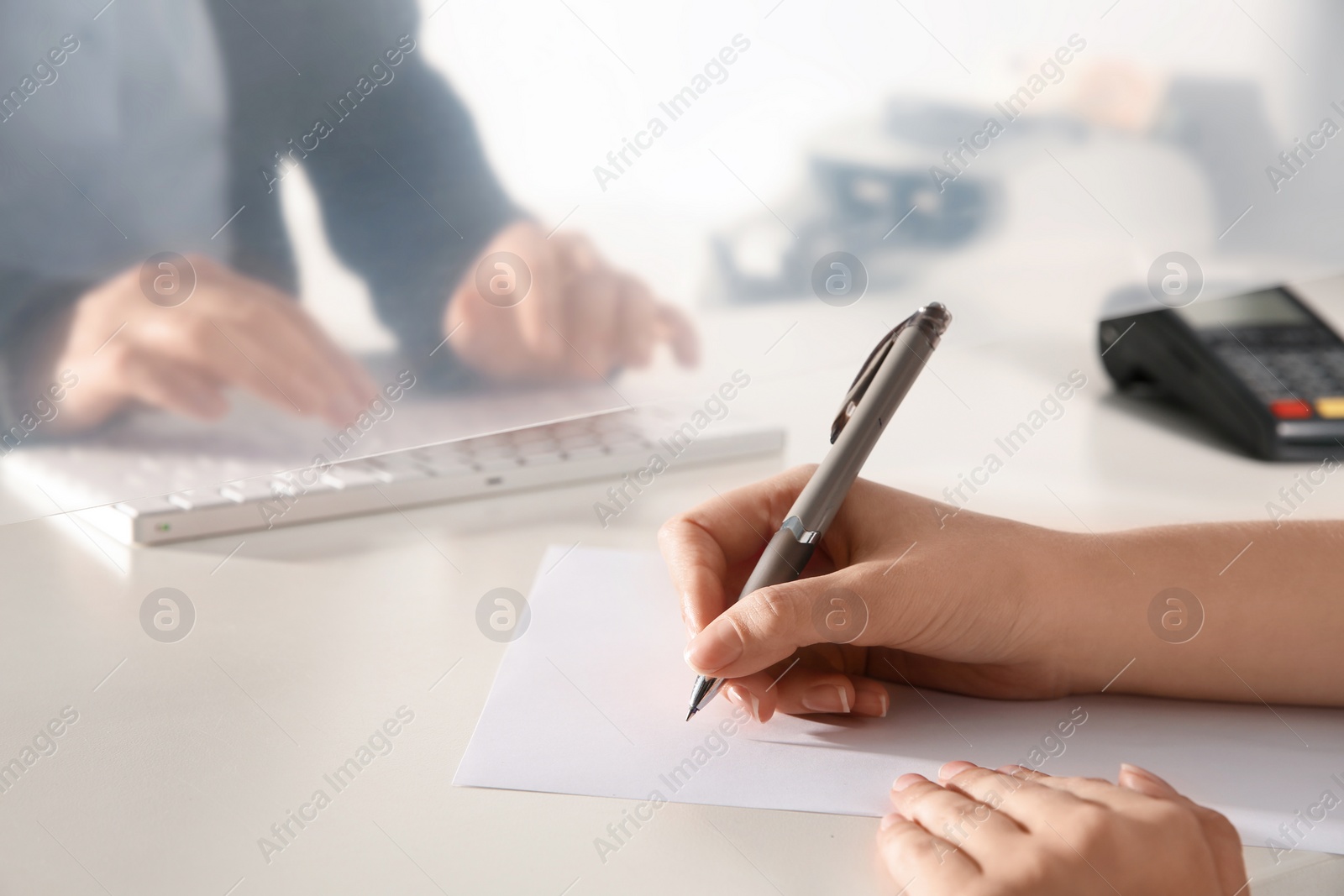 Photo of Woman filling blank at cash department window, closeup