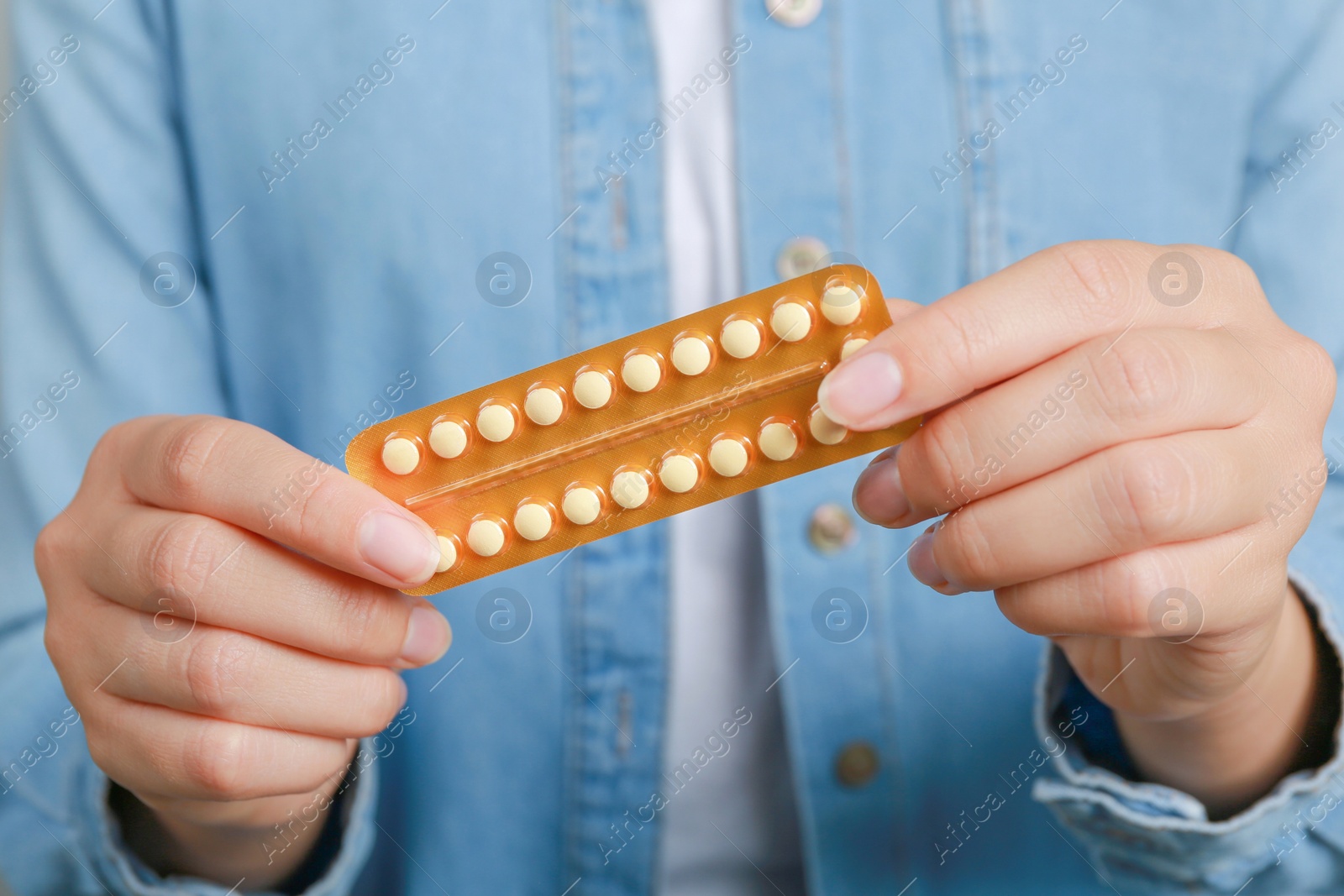 Photo of Woman holding blister with birth control pills, closeup