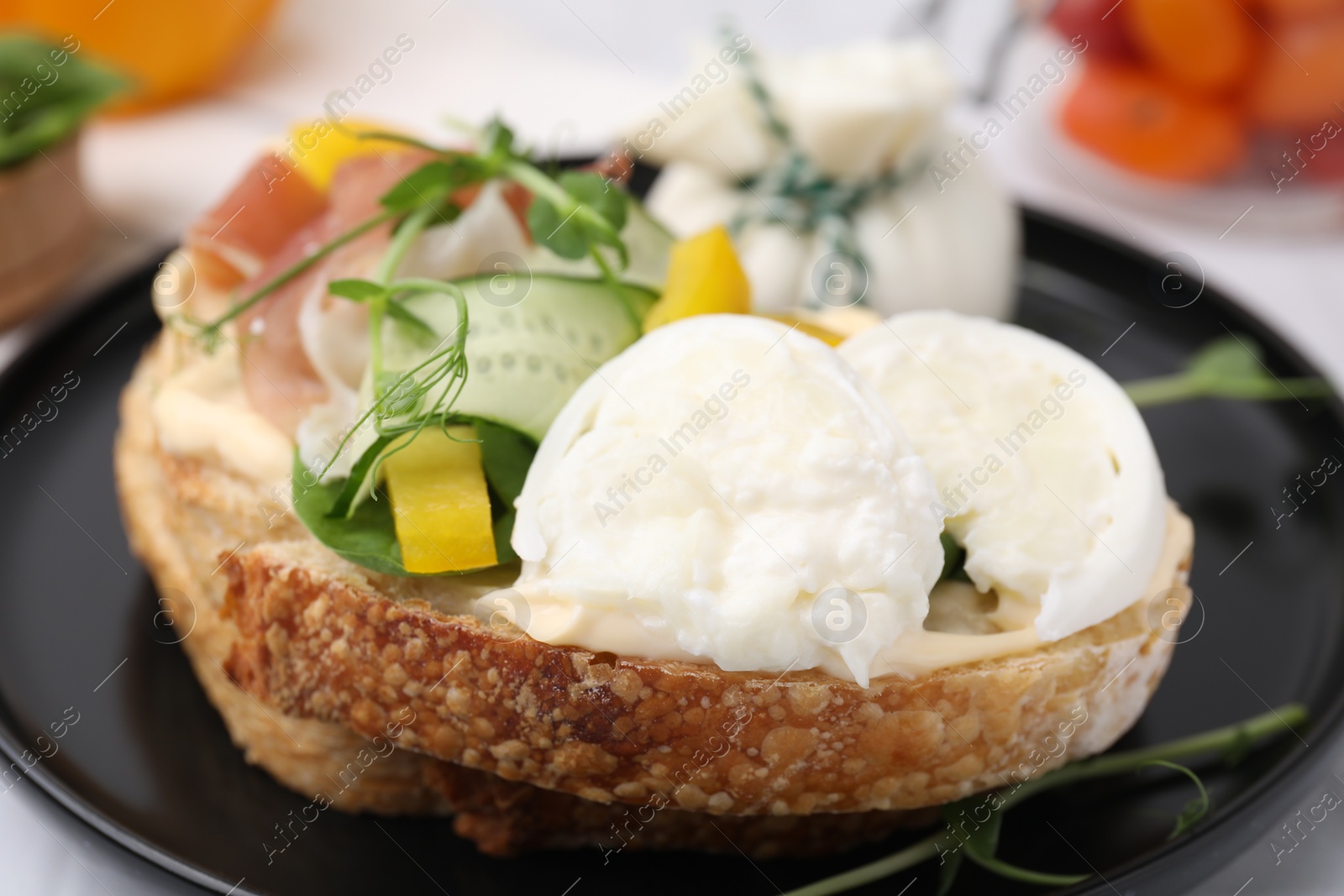 Photo of Tasty sandwich with burrata cheese and vegetables on table, closeup