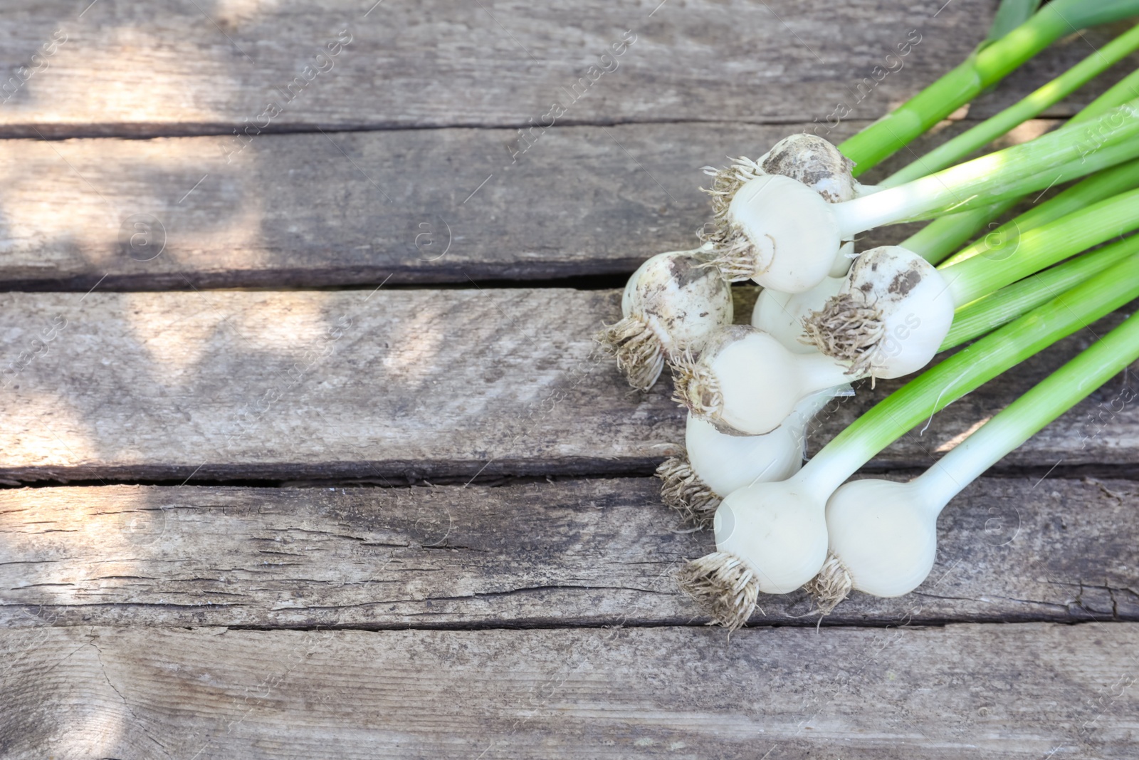 Photo of Fresh garlic bulbs on wooden background, top view