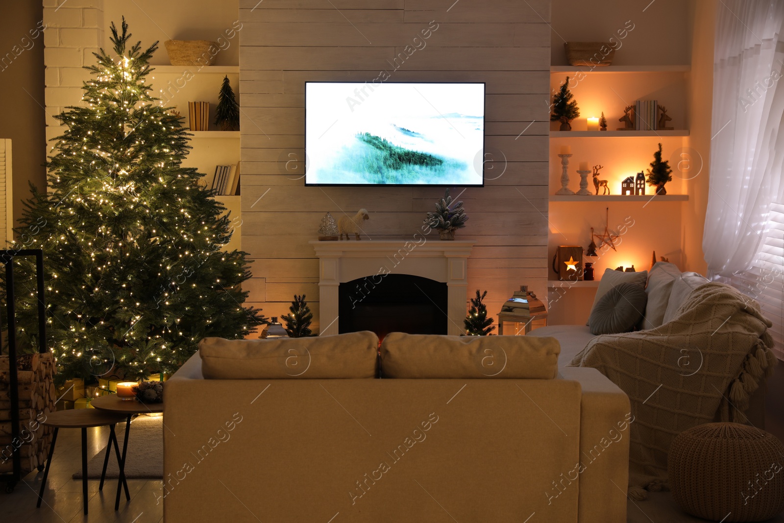 Photo of Stylish living room interior with TV set, Christmas tree and fireplace