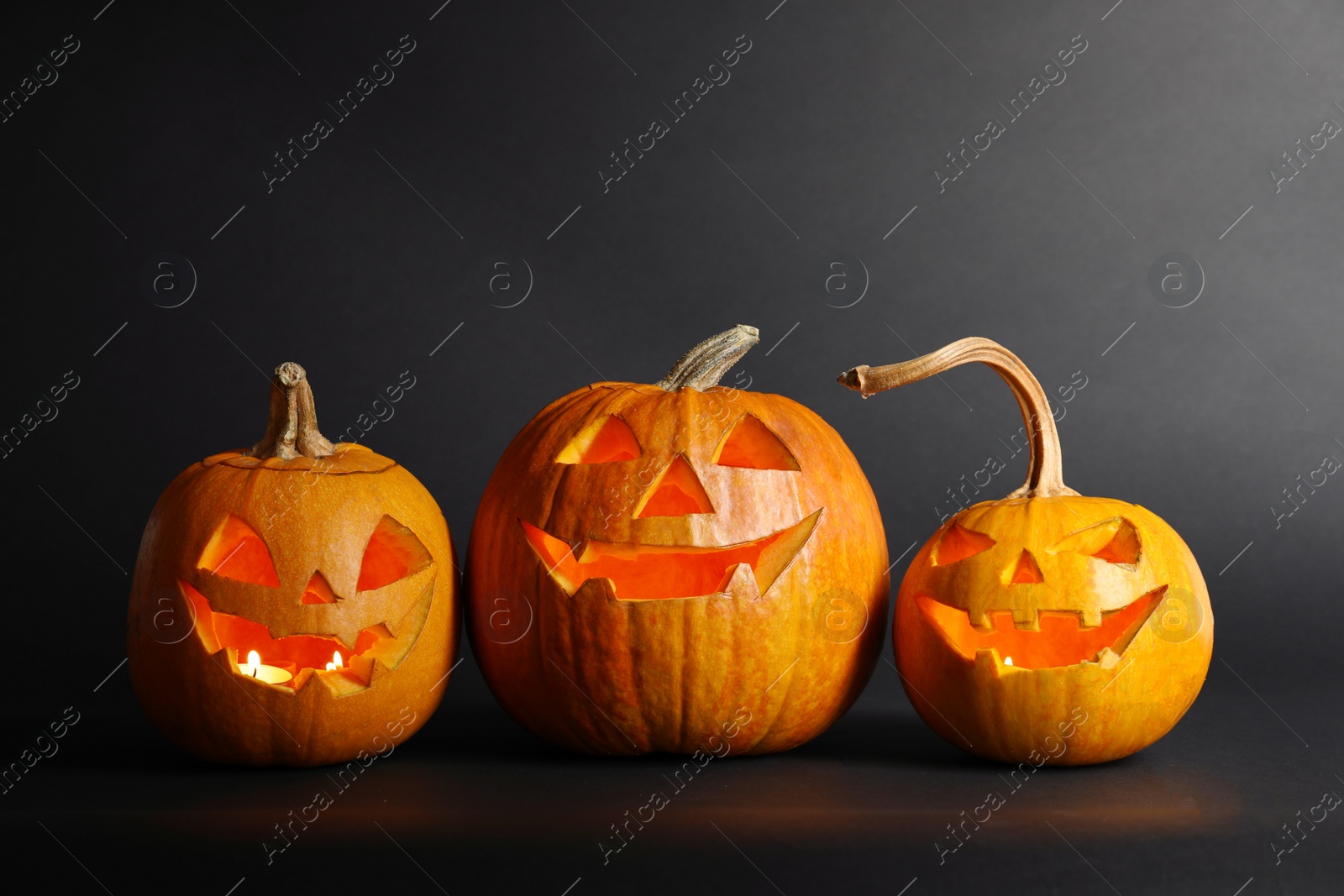 Photo of Halloween pumpkin head jack lanterns on dark background