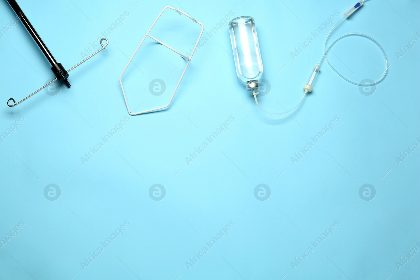 Photo of IV infusion set on light blue background, flat lay. Space for text