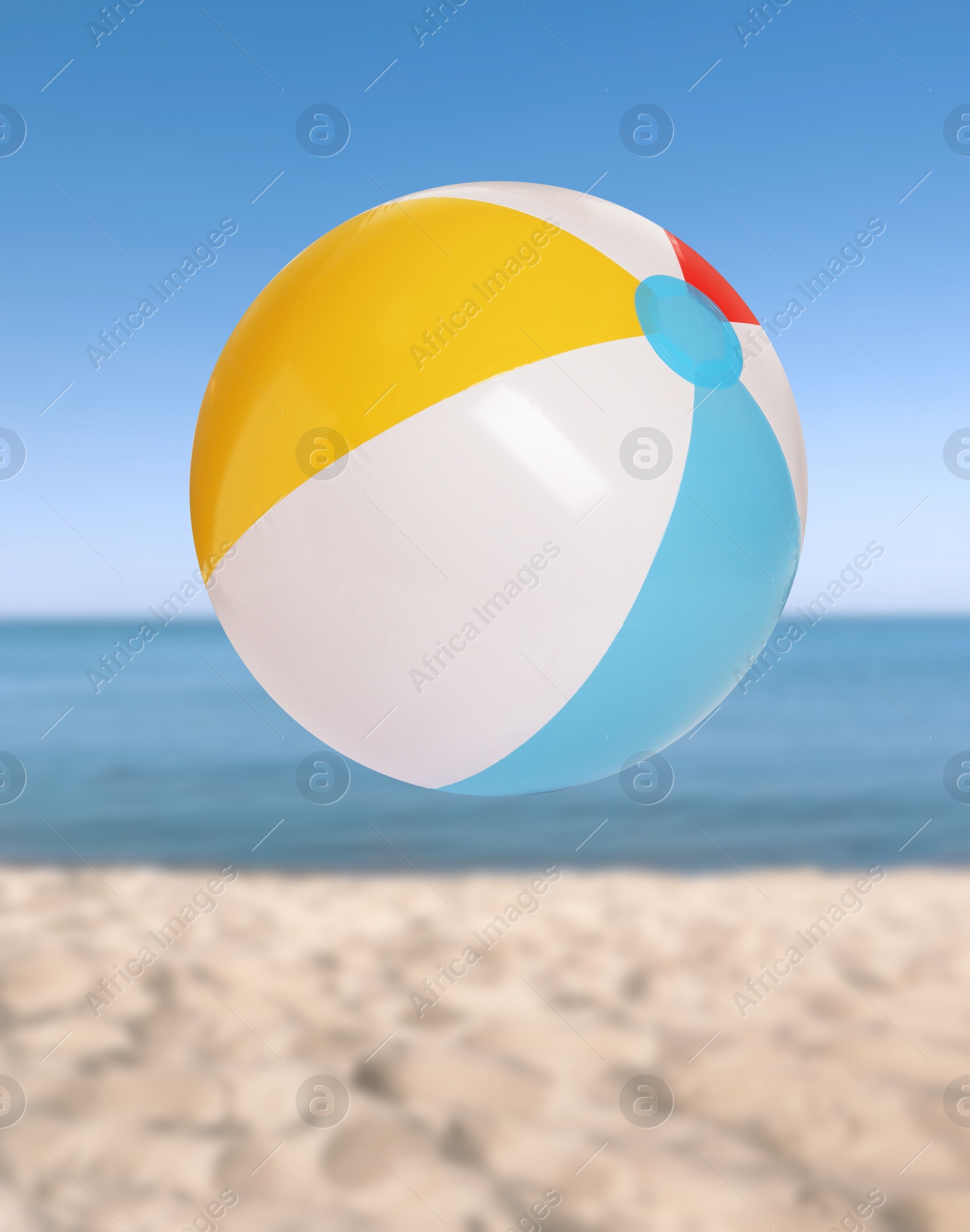 Image of Colorful inflatable beach ball and seascape on background