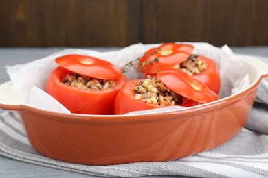 Photo of Uncooked stuffed tomatoes with minced beef, bulgur and mushrooms in baking dish on table, closeup