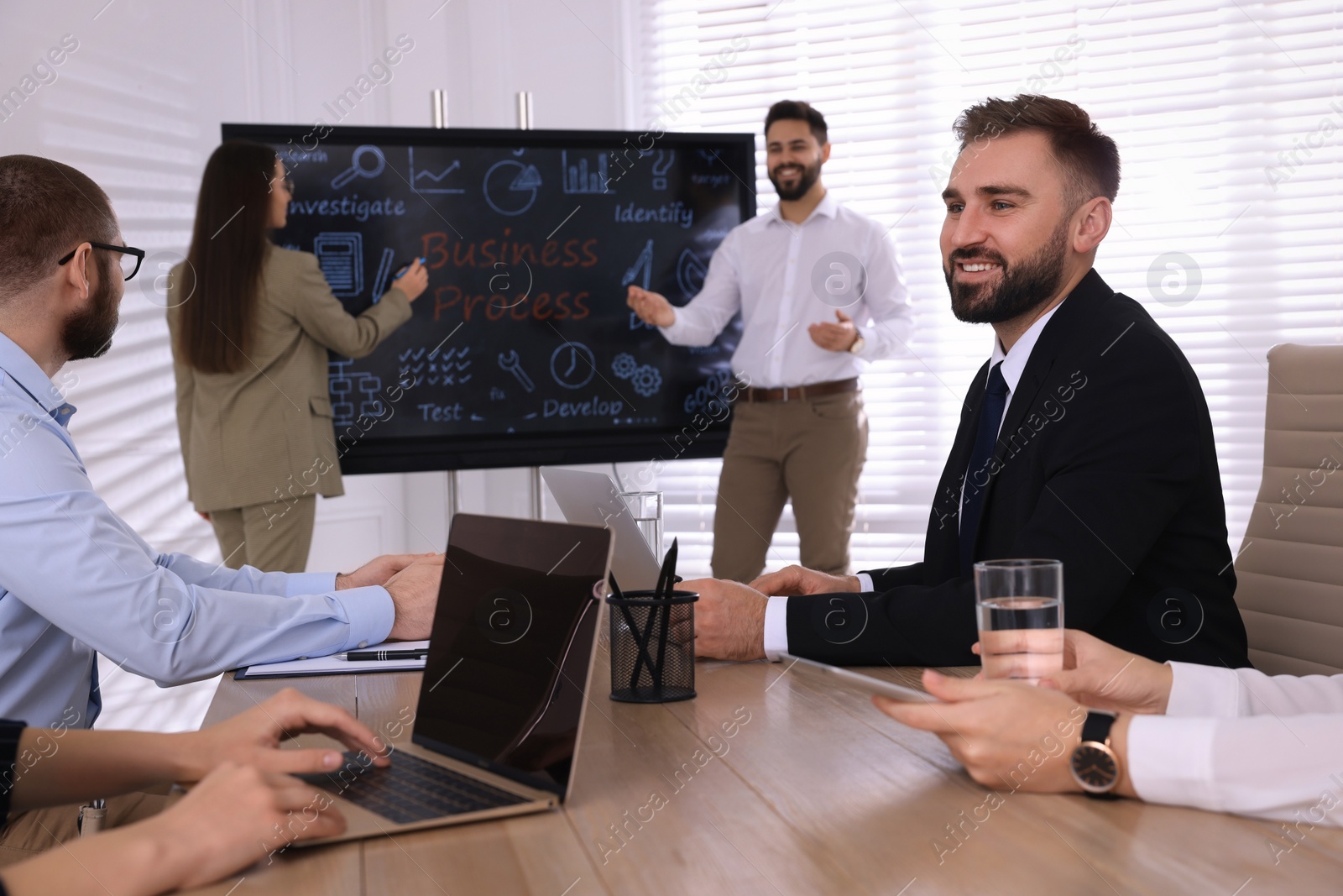 Photo of Business training. People in meeting room with interactive board